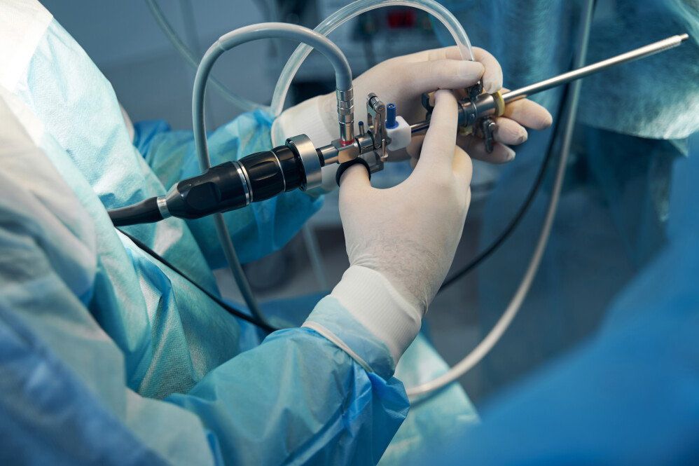 Close up photo hands in latex gloves holding a modern hysteroscope